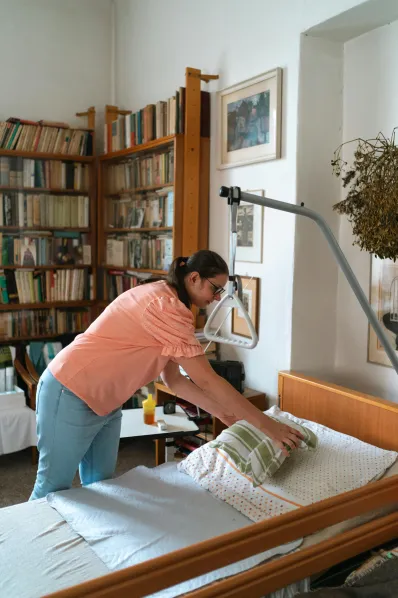 Une aide à domicile aidant une personne âgée